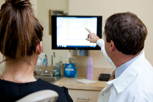 Photo of dentist explaining periodontal dentistry on computer screen