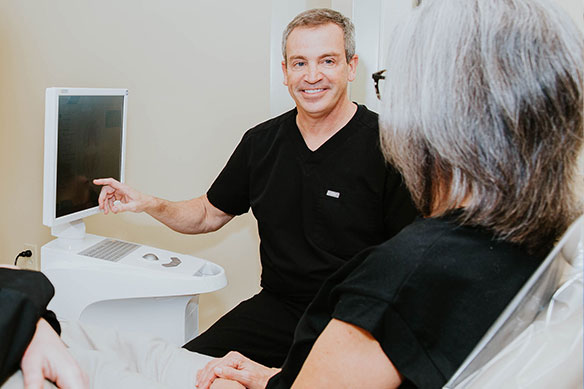 Photo of Greensboro dentist showing patient a computer screen