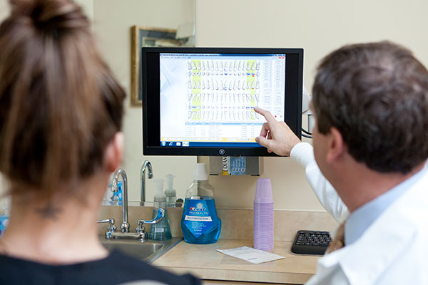 Photo of Dr. Welch showing dental patient fillings computer screen